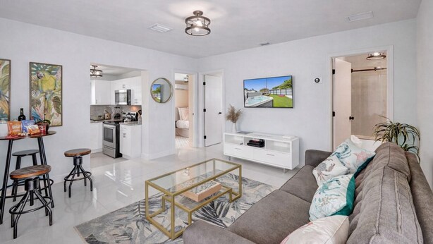 A modern living room with a sofa, coffee table, and kitchen area visible in the background. - The Island Shoes (Miami)