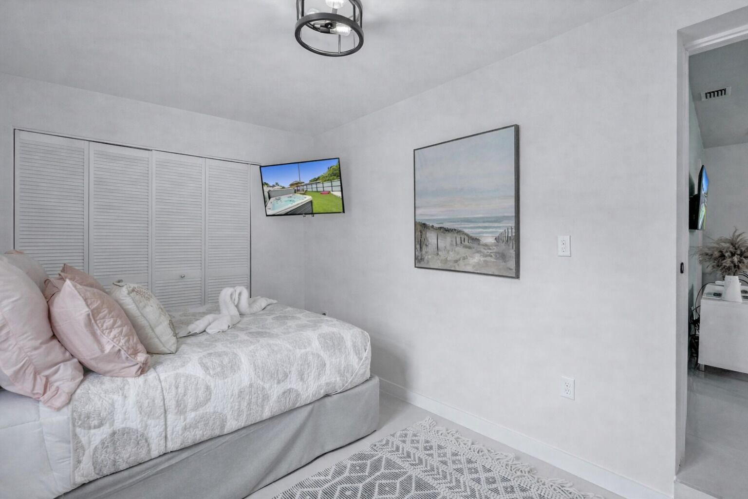 A bedroom with a bed, a closet, and two framed pictures on the wall.