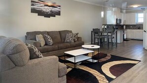 Ein modernes Wohnzimmer mit einer Couch, einem Couchtisch und einem Gemälde an der Wand.