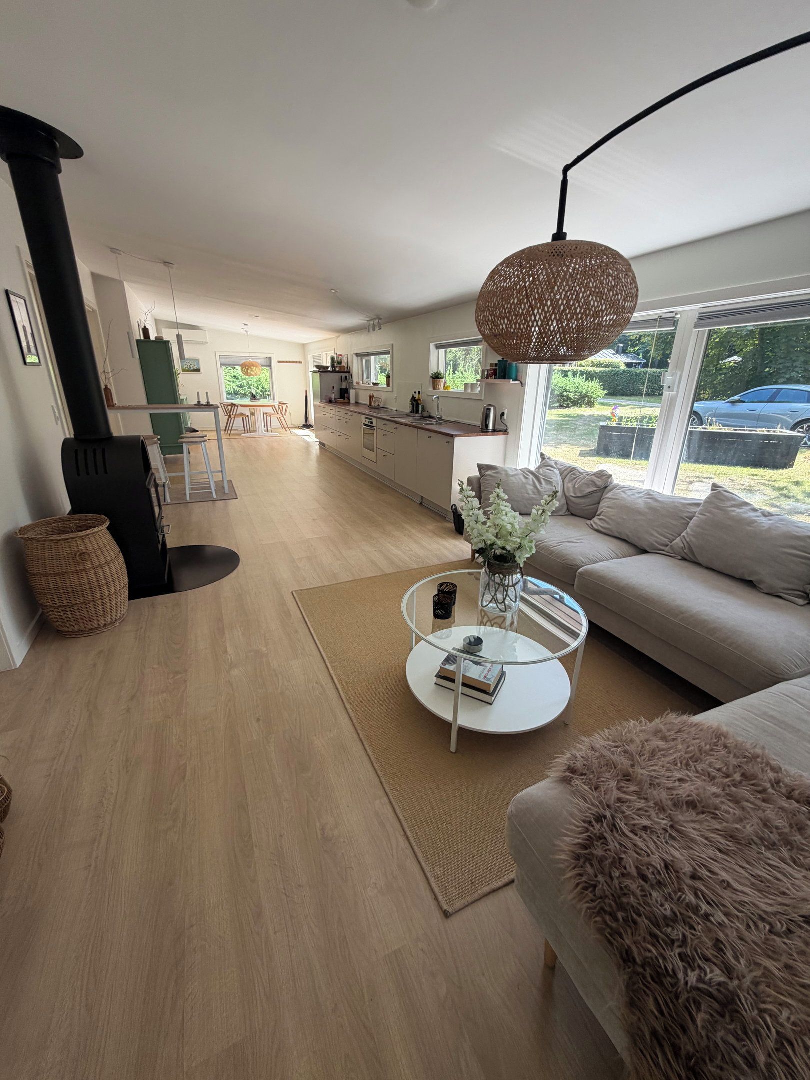Un salon moderne avec un canapé, une table basse et, au fond, un coin repas.