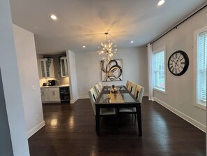 A spacious dining area with a modern chandelier, a dining table with chairs, and a large abstract painting on the wall. - World Cup 2026-Large 5BR Home-Near MetLife & NYC (River Edge)