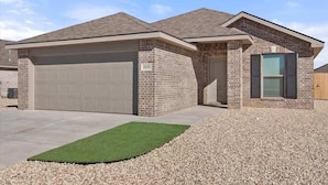 A two-story house with a garage, a brick exterior, and a gravel driveway. - Langford House - 3BR/2BA - Family Friendly (Lubbock)