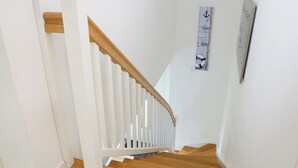 Un escalier avec des rampes blanches et des marches en bois.