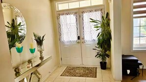 A clean, modern entrance with a double door, a mirror, and potted plants. - Lola's Place Luxury 4BR with 4BEDS  Close to fall, sleeps 8... (Welland)
