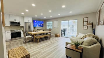 Apartamento Deluxe, balcón, vistas al mar | Zona de estar | Smart TV de 75 pulgadas con canales por cable, una oficina