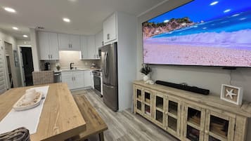 Appart'hôtel Deluxe, balcon, vue océan | Coin séjour | TV connectée de 75 pouces avec chaînes par câble, espaces bureaux