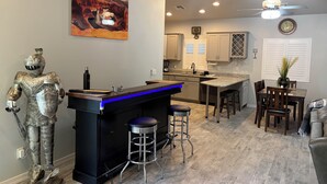 Una cocina moderna con barra, una mesa de comedor y una estatua.