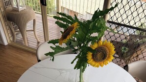 Et rundt marmorbord med en vase solsikker.