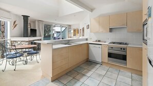 A modern kitchen with wooden cabinets, a built-in stove, and a dishwasher.
