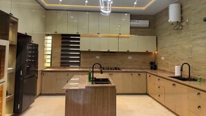 Une cuisine moderne dotée d’un îlot central, d’appareils électroménagers intégrés et d’un design épuré.