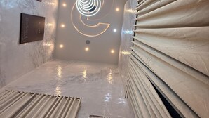 Un intérieur moderne avec un luminaire central, un sol en marbre et un climatiseur fixé au mur.