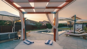 A covered outdoor area with a pool, lounge chairs, and a canopy structure. - Slavonian home with pool, jacuzzi, barbecue and family fun (Požega)