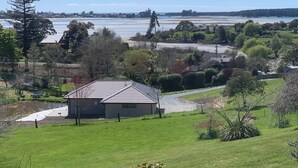A residential area with a house, a pond, and a view of a beach and forest. - Private attractive single story bungalow, sleeping 4 people. (Redwood Valley)