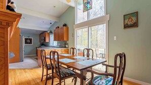 Une cuisine spacieuse avec des meubles en bois, une table à manger avec des chaises et une grande fenêtre qui laisse entrer la lumière naturelle.