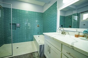 Ein Badezimmer mit Duschkabine, einer Badewanne, einem Waschbecken mit Spiegel und einer Toilette.