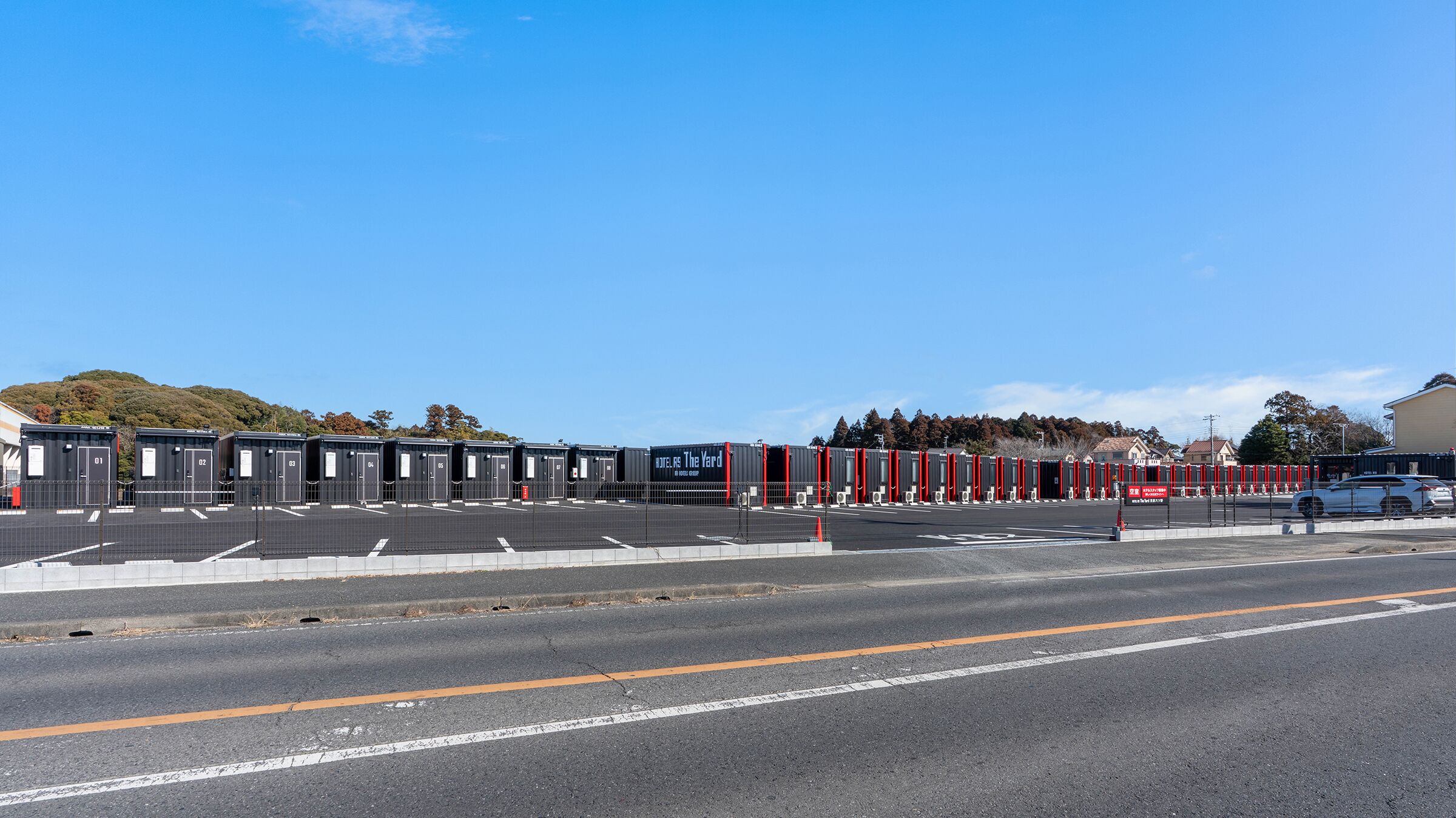 A row of hotel rooms with a clear view of the road in front.