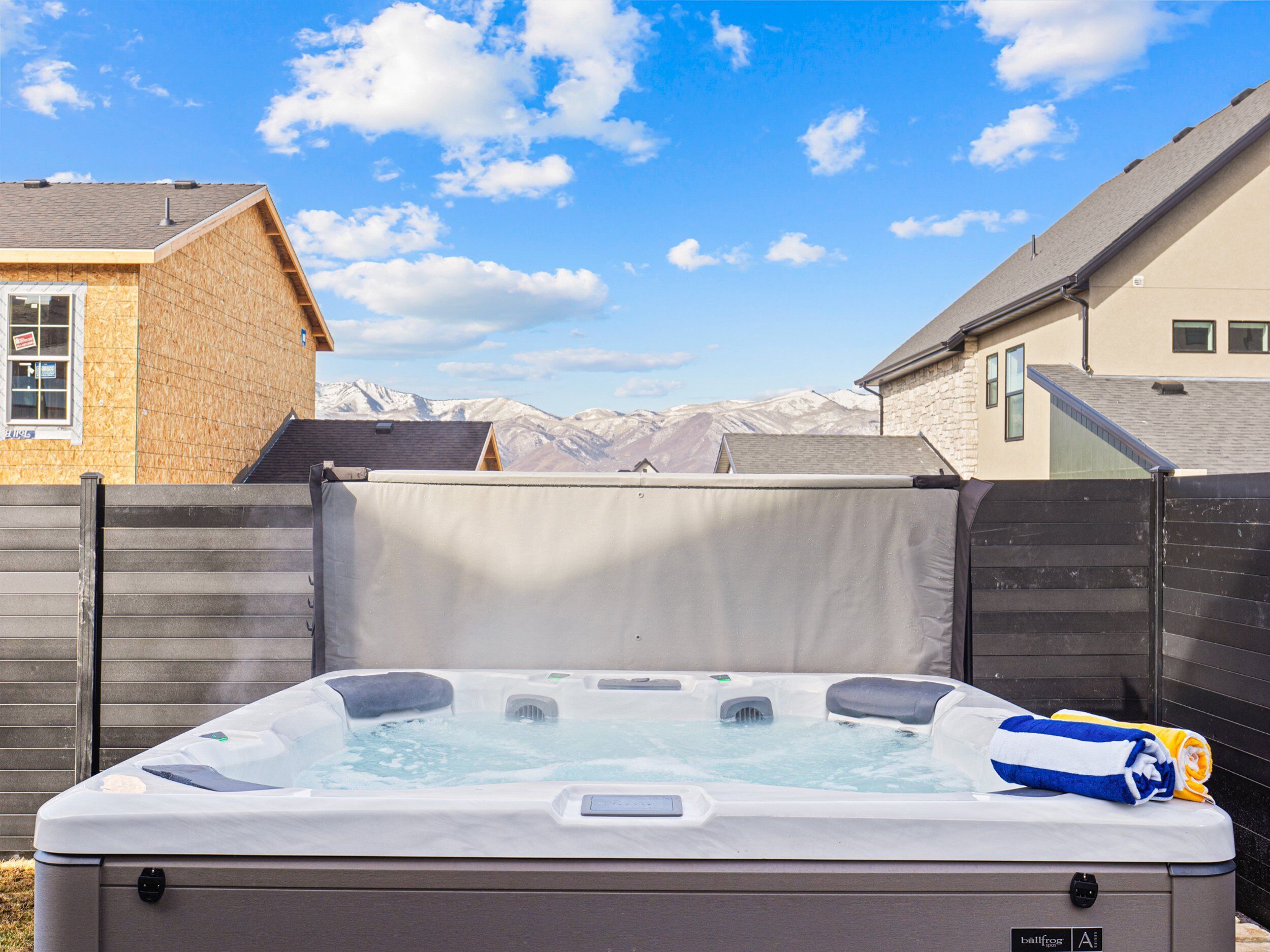 A hot tub in a backyard with a view of mountains in the background.