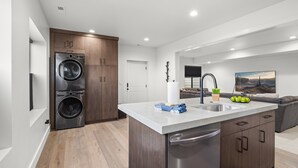 A modern kitchen with a central island, built-in appliances, and a dining area with a view.