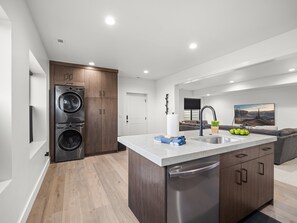 A modern kitchen with a central island, built-in appliances, and a dining area with a view. - Modern Mountain Escape, Hot Tub, Deer Valley Close (Heber City)
