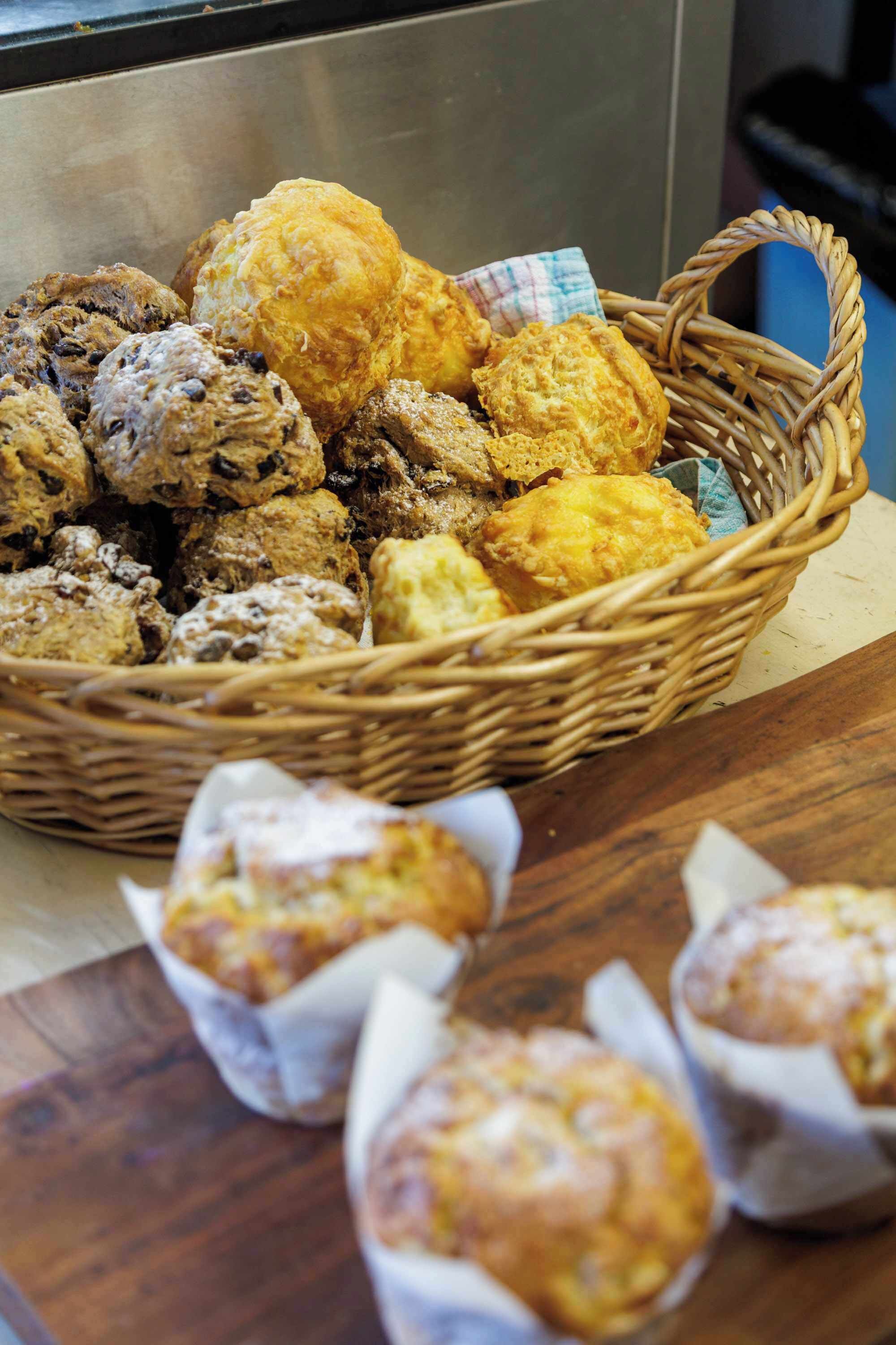 A basket of baked goods on a wooden surface.