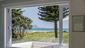 Una stanza con una grande finestra vista spiaggia e mare.