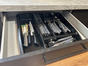 A drawer with utensils and a knife. - The Phoenix  (Swansea)