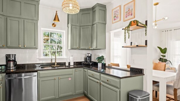 A kitchen with green cabinets, a stainless steel dishwasher, a coffee maker, and a hanging light fixture. - Charleston 3BR Home · 3 Baths · Porches · Dogs OK (North Charleston)