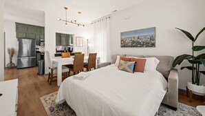 A modern hotel room with a bed, a sofa, a dining area, and a kitchen. - Charleston 3BR Home · 3 Baths · Porches · Dogs OK (North Charleston)