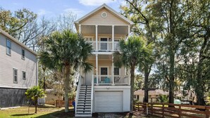 A two-story house with a balcony, a garage, and a front yard with palm trees. - Charleston 3BR Home · 3 Baths · Porches · Dogs OK (North Charleston)