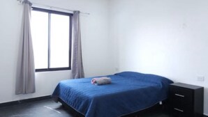 A bedroom with a bed, a ceiling fan, an air conditioning unit, and a window with curtains. - Quinta Ideal for Families: 4 Bedrooms, Swimming Pool, Jacuzzi and Billiards (Portal del Norte)