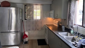 A kitchen with a stainless steel refrigerator, a microwave, a stove, and a sink. - 5 Bedroom Cottage at Rice Lake! (Alnwick/Haldimand)