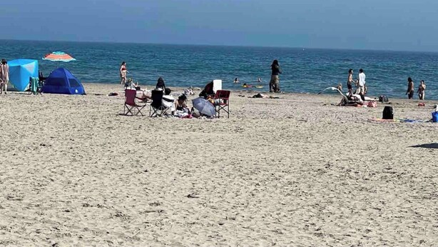A beach with tents, chairs, and people. - 5 Bedroom Cottage at Rice Lake! (Alnwick/Haldimand)