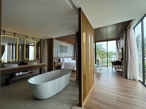 A modern bathroom with a freestanding bathtub, dual sinks, and a large mirror with illuminated edges. - Hoi An Ocean Villas (Hoi An)