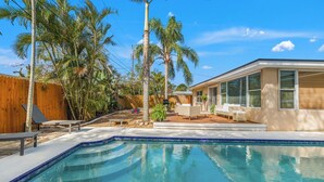 A swimming pool with lounge chairs and a wooden fence. - Coastal Retreat w/ Heated Pool & Games (Largo)