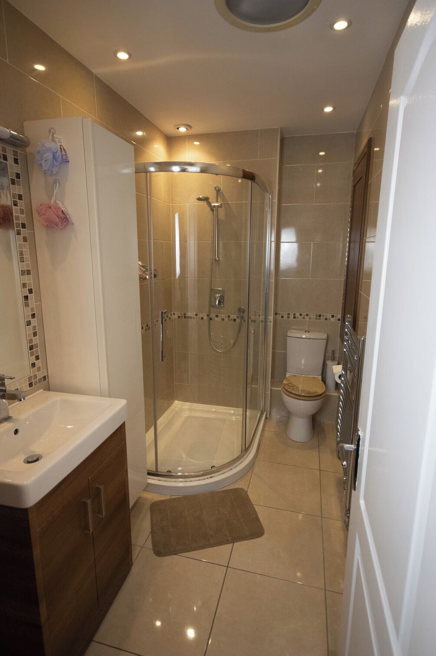 A modern bathroom with a glass shower enclosure, a toilet, and a sink.