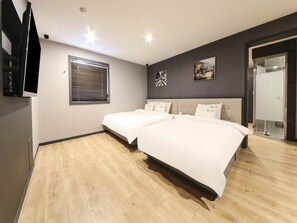 A bedroom with two beds, a window with blinds, and a flat-screen TV mounted on the wall. - MORASTAY (Busan)