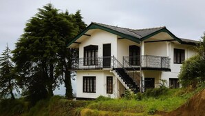 A two-story building with a balcony and a staircase leading to the upper floor. - The Crown's Lodge Misty Hideaway  (Nuwara eliya)