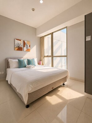 Un dormitorio moderno con una cama grande, un ventanal con cortinas y dos obras de arte colgadas en la pared.