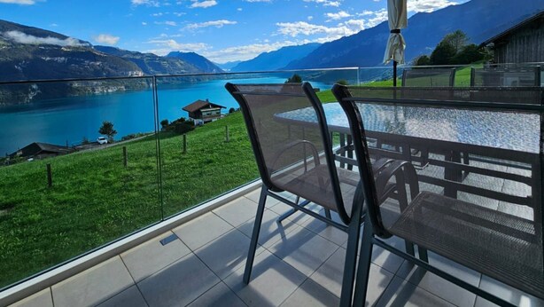 Een balkon met uitzicht op een meer en bergen.