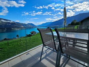 Uma varanda com vista para um lago e montanhas.