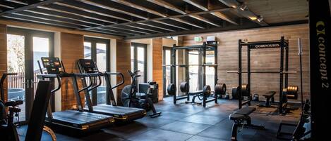 A gym with treadmills, elliptical machines, and weightlifting equipment.
