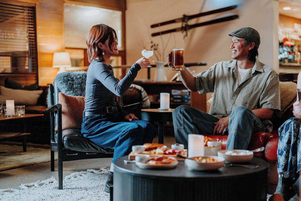 A cozy living room with a fireplace, a coffee table with snacks, and a comfortable seating area.