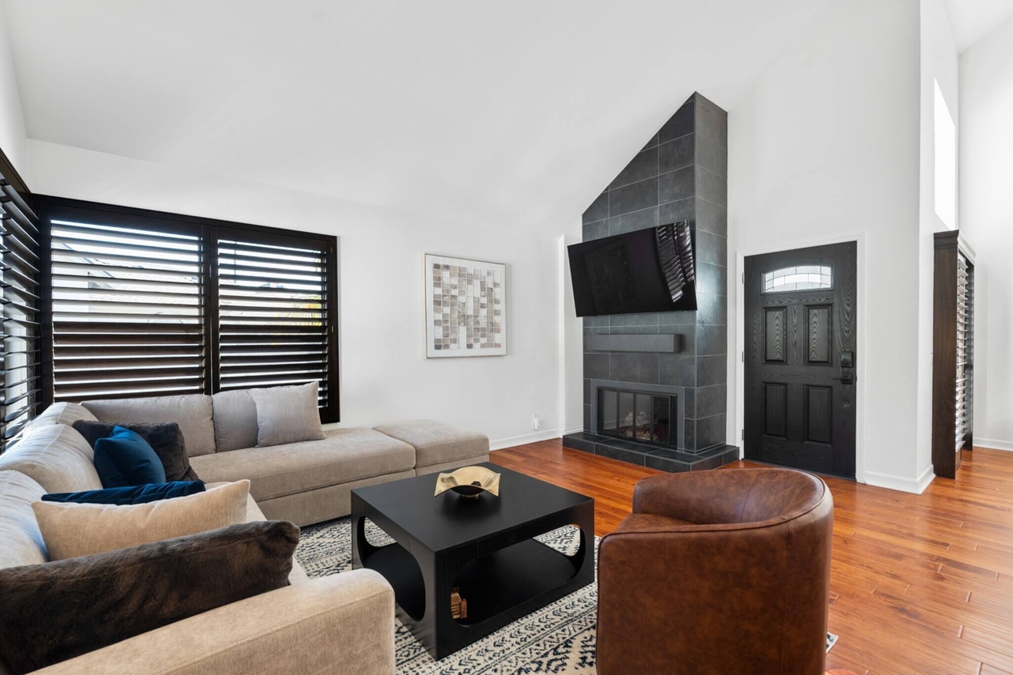 Una sala de estar con un sofá, una mesa de centro, una chimenea y una puerta.
