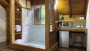 A compact room with a shower, a small kitchenette, and a wooden ceiling. - Sabifi River Resort (Castle Bruce)