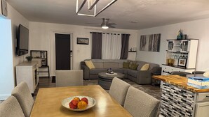 Una sala moderna con una mesa de comedor, sofá y una zona de cocina.
