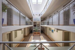 A modern interior with a central staircase, glass railings, and a bench. - Elevated Mount Location, Beach, Shops, 2 Car Parks (Mount Maunganui)