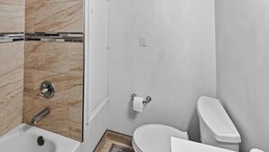 Ein Badezimmer mit Dusche, Toilette und Waschbecken.