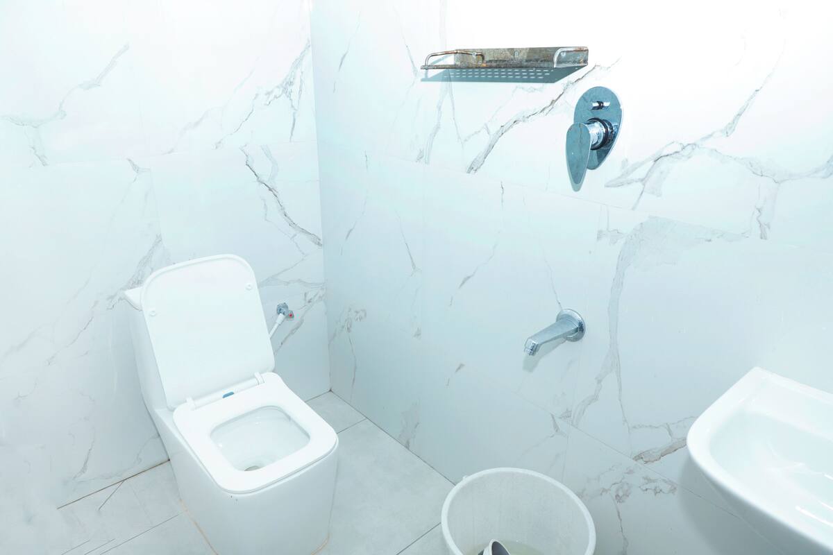 Een badkamer met toilet, bidet en een klein emmertje.