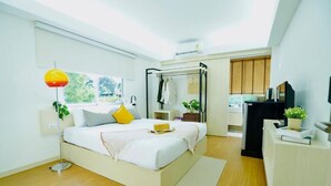 A modern bedroom with a large bed, bedside tables, a wardrobe, and a desk with a chair. - House Hotel North Pattaya (Pattaya)