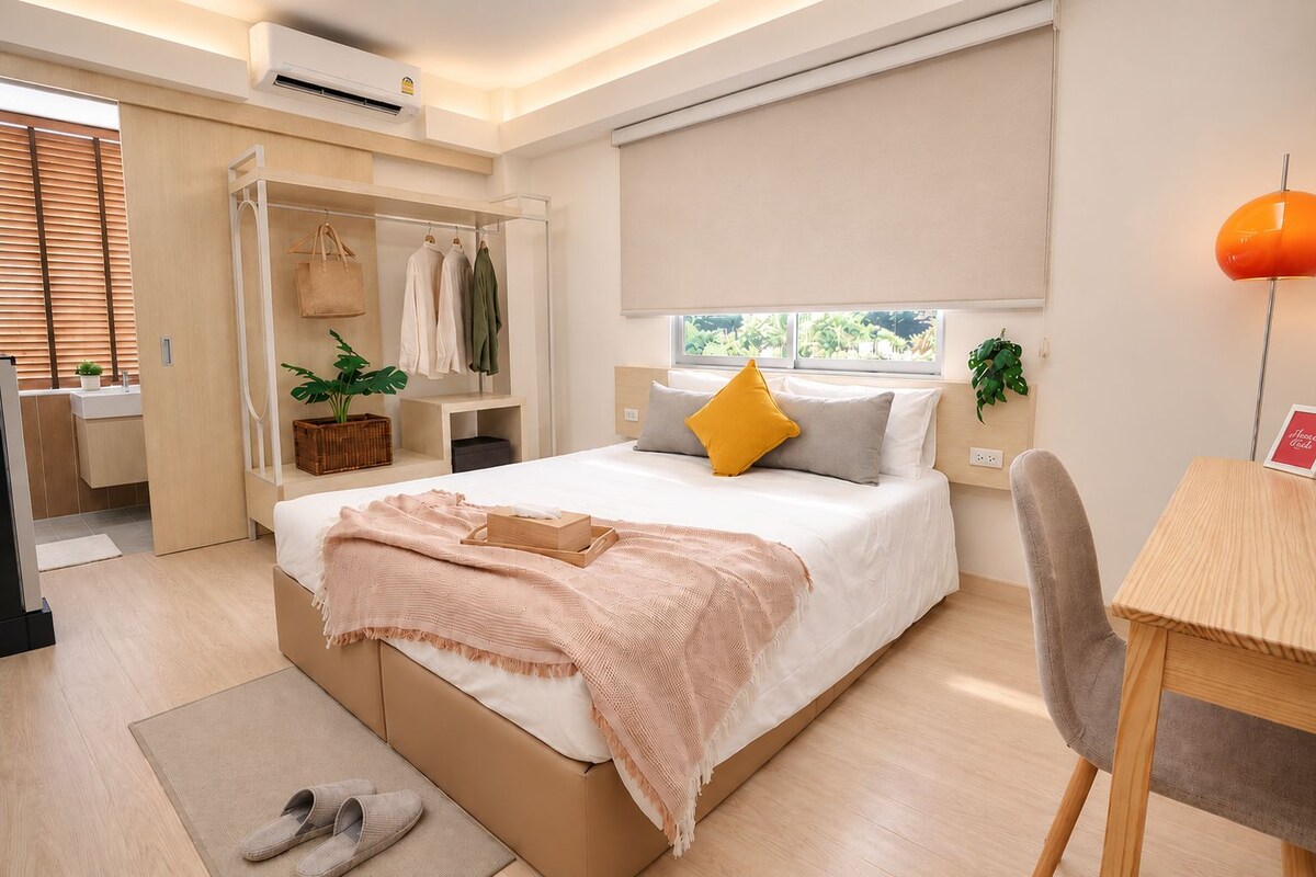 Une chambre moderne avec un lit, une table de chevet, une chaise et une fenêtre donnant sur un beau paysage.